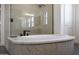 Close up of an elegant soaking tub with marble surround and glass shower panel at 20775 W Rattler Rd, Buckeye, AZ 85396