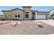 Beautiful single-story home showcasing a stone facade, tile roof, and well-maintained desert landscaping at 20775 W Rattler Rd, Buckeye, AZ 85396