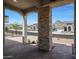 Inviting front porch with stone columns and brick flooring, showcasing neighborhood views at 20775 W Rattler Rd, Buckeye, AZ 85396