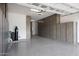 View of large garage with gray wood-tone cabinets on walls, epoxy floors and equipment at 20775 W Rattler Rd, Buckeye, AZ 85396