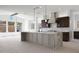 Bright, open kitchen with a large marble island, stainless steel appliances, and dark wood cabinets at 20775 W Rattler Rd, Buckeye, AZ 85396