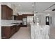 Bright, open kitchen with a large marble island, stainless steel appliances, and dark wood cabinets at 20775 W Rattler Rd, Buckeye, AZ 85396