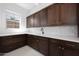 Stylish laundry room features sleek dark cabinetry, white countertops, and modern fixtures, bathed in natural light at 20775 W Rattler Rd, Buckeye, AZ 85396
