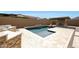 Backyard pool area with a stone surround, water feature, built-in BBQ and covered outdoor fireplace at 20775 W Rattler Rd, Buckeye, AZ 85396