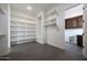 Spacious walk-in closet with open white shelves and dark tile flooring at 20775 W Rattler Rd, Buckeye, AZ 85396