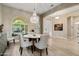 Elegant dining area featuring a chandelier, tile flooring, and a view of the front yard at 20977 W Mariposa St, Buckeye, AZ 85396