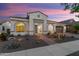 Twilight front view featuring desert landscape, tile roof, and welcoming entrance on a single-story home at 20977 W Mariposa St, Buckeye, AZ 85396