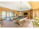 Spacious game room featuring two pool tables, comfortable seating, and ample natural light at 20977 W Mariposa St, Buckeye, AZ 85396