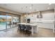 Modern kitchen with white cabinets, stainless steel appliances, a center island, and outdoor pool views at 20977 W Mariposa St, Buckeye, AZ 85396