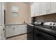 Convenient laundry room boasts ample counter space, storage cabinets, and modern washer/dryer units at 20977 W Mariposa St, Buckeye, AZ 85396