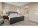 Serene bedroom with a view into the bathroom and two bedside tables with lamps at 20977 W Mariposa St, Buckeye, AZ 85396