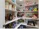 Organized walk-in pantry with shelving stocked with various food items and household goods at 20977 W Mariposa St, Buckeye, AZ 85396