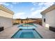 Inviting pool and hot tub with tiled patio, lounge chairs, and desert landscaping at 20977 W Mariposa St, Buckeye, AZ 85396