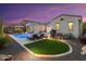 Beautiful backyard pool with lounge chairs, lush landscaping, and a cozy artificial turf area at 20977 W Mariposa St, Buckeye, AZ 85396