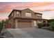 Beige stucco two-story home featuring a tile roof, manicured lawn, and a two-car garage at sunset at 2270 E Honeysuckle Pl, Chandler, AZ 85249