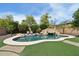 Lush backyard showcasing a sparkling pool with a stone slide and beautiful landscaping at 2270 E Honeysuckle Pl, Chandler, AZ 85249
