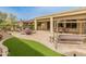 Backyard patio with outdoor furniture set, swing, grass area, and desert landscaping at 26473 W Runion Ln, Buckeye, AZ 85396