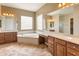 Bright bathroom featuring dual sinks, a soaking tub, and a vanity area, all complemented by neutral tones and natural light at 26473 W Runion Ln, Buckeye, AZ 85396