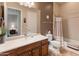 Inviting bathroom featuring a wood vanity, neutral walls, a large mirror, and tile flooring at 26473 W Runion Ln, Buckeye, AZ 85396