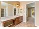Bright bathroom with dual sinks, a vanity area, and access to the walk-in closet at 26473 W Runion Ln, Buckeye, AZ 85396