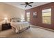 Comfortable bedroom with ceiling fan, carpet, windows and a large bed, complemented by calming neutral tones at 26473 W Runion Ln, Buckeye, AZ 85396