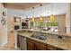 Spacious kitchen with granite counters, modern appliances, pendant lighting, and a breakfast bar at 26473 W Runion Ln, Buckeye, AZ 85396