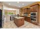A gourmet kitchen features wood cabinets, granite counters, stainless appliances, and a spacious center island at 26473 W Runion Ln, Buckeye, AZ 85396