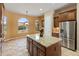 Bright kitchen with granite counters, island, stainless fridge, and large windows at 26473 W Runion Ln, Buckeye, AZ 85396