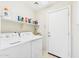 Functional laundry room equipped with a washer, dryer, shelving, and a door to the outside at 28942 N Lazurite Way, San Tan Valley, AZ 85143