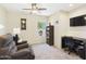 Cozy living room with a comfortable armchair, ceiling fan, and desk, perfect for relaxation and work at 28942 N Lazurite Way, San Tan Valley, AZ 85143
