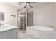 An elegant bathroom with a shower and a soaking tub featuring granite finishings provides a spa-like retreat at 29756 N Varnum Rd, San Tan Valley, AZ 85143