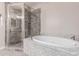 An elegant bathroom with a shower and a soaking tub featuring granite finishings provides a spa-like retreat at 29756 N Varnum Rd, San Tan Valley, AZ 85143