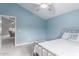 Light-filled bedroom featuring light blue walls, ceiling fan, and metal bed frame at 29756 N Varnum Rd, San Tan Valley, AZ 85143