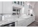 Stylish kitchen with marble countertops, white cabinets, and a stainless steel sink at 29756 N Varnum Rd, San Tan Valley, AZ 85143