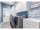 This convenient laundry room boasts modern machines, ample cabinet space, and stylish tile for effortless chores at 29756 N Varnum Rd, San Tan Valley, AZ 85143