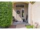 Welcoming front porch with a decorative door, wreath, potted plants, and a cozy chair, creating a charming entryway at 30430 N 42Nd Pl, Cave Creek, AZ 85331