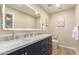 Modern bathroom features double sinks, marble countertop, navy blue cabinets, and a large, lighted mirror at 3209 E Marilyn Rd, Phoenix, AZ 85032