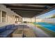Relaxing covered patio featuring comfortable seating area with a tennis court and manicured lawn in the background at 3209 E Marilyn Rd, Phoenix, AZ 85032