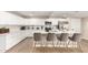 Bright kitchen featuring a large island with bar seating, white cabinets, and modern appliances at 3209 E Marilyn Rd, Phoenix, AZ 85032
