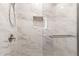 Shower featuring marble tile, a rainfall shower head, a shower niche, and a glass door at 3209 E Marilyn Rd, Phoenix, AZ 85032