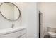 Modern bathroom featuring a vanity sink with round mirror, white walls, and tile flooring at 3591 S Ranger Trl, Gilbert, AZ 85297