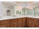 Bathroom features dual sinks, white counters, wood vanity and large mirror at 3591 S Ranger Trl, Gilbert, AZ 85297