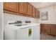 A laundry room with side-by-side washer and dryer and overhead storage cabinets at 3591 S Ranger Trl, Gilbert, AZ 85297