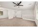 Bright living room features neutral carpet, ceiling fan, bright windows, and white walls at 3591 S Ranger Trl, Gilbert, AZ 85297