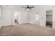 Spacious main bedroom featuring a ceiling fan, neutral carpet, and ensuite bathroom and walk in closet at 3591 S Ranger Trl, Gilbert, AZ 85297