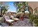 This covered patio features lounge chairs, pavers, and mature landscaping at 3980 E Sierra Vista Dr, Paradise Valley, AZ 85253