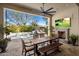 Covered patio with TV and fireplace overlooking a sparkling pool with mature trees at 3980 E Sierra Vista Dr, Paradise Valley, AZ 85253