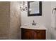 Elegant half bathroom with stone accent wall and ornate vanity at 4020 E Laurel Ln, Phoenix, AZ 85028