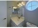 Bright bathroom vanity with an oval window that adds an architectural touch and fills the space with natural light at 4020 E Laurel Ln, Phoenix, AZ 85028
