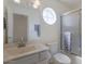 Bright bathroom with a shower/tub combo, white vanity and a unique round window at 4020 E Laurel Ln, Phoenix, AZ 85028
